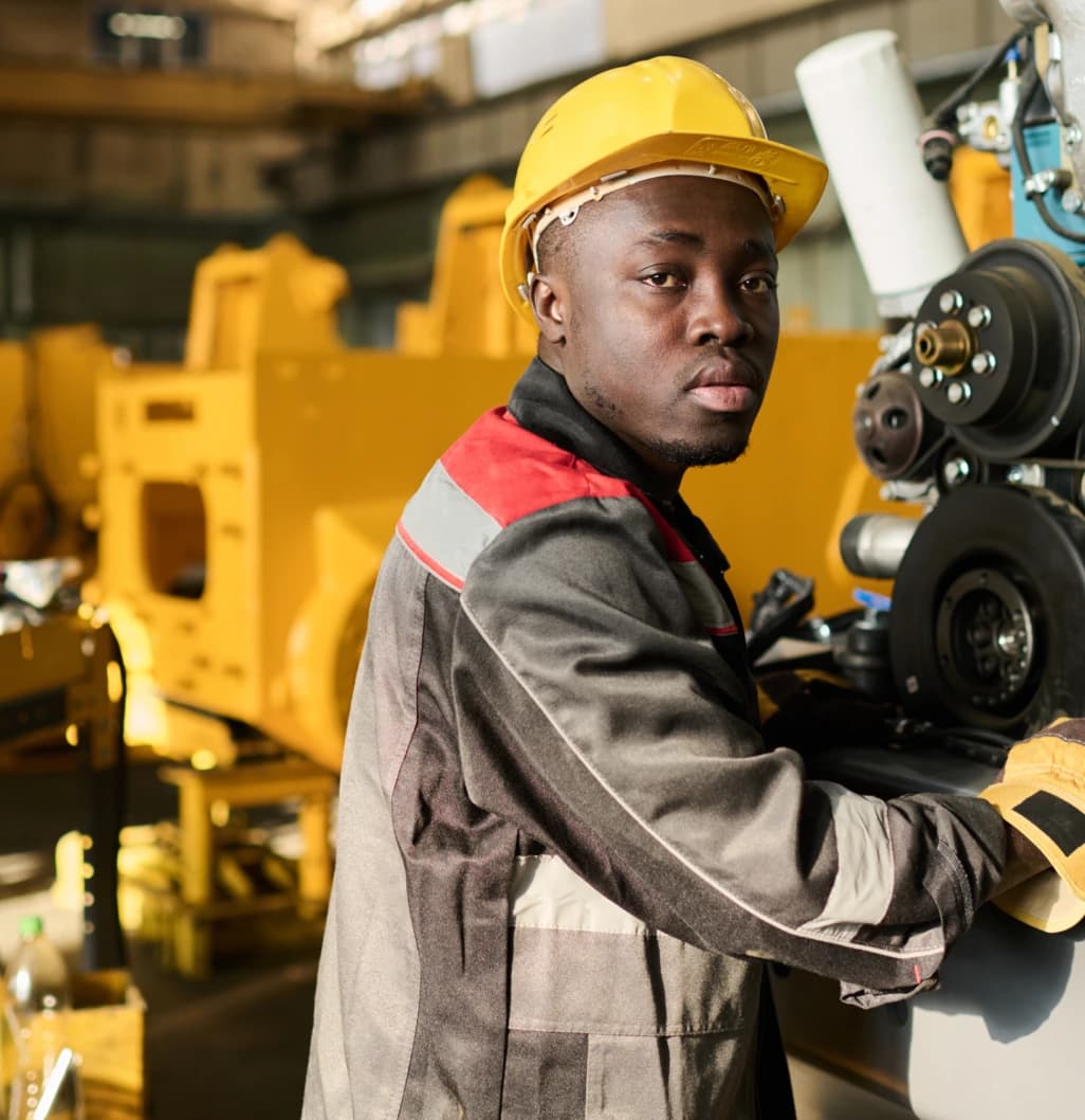 Worker operating industrial machinery in protective equipment
